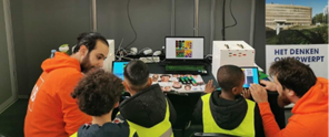 Foto van onderzoekers die uitleg geven aan kinderen