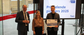 De winnaar van de wedstrijd Prikkelende Pioniers poseert met een cheque, samen met de secretaris-generaal van FWO en de verantwoordelijke van Scimingo.